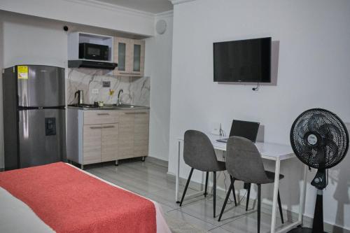 a room with a kitchen and a table with chairs at Apartahotel Poblado-Aguacatala in Envigado