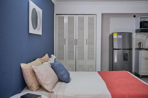 a bedroom with blue walls and a bed with pillows at Apartahotel Poblado-Aguacatala in Envigado