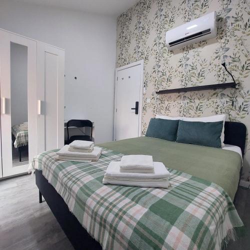 a bedroom with a green bed with a black chair at Casa das Olarias in Castelo Branco