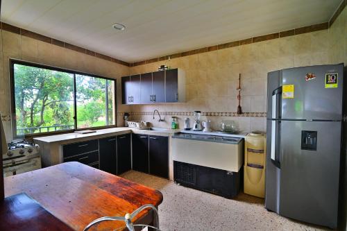 a kitchen with a refrigerator and a table in it at Villa Hortencia in Fusagasuga