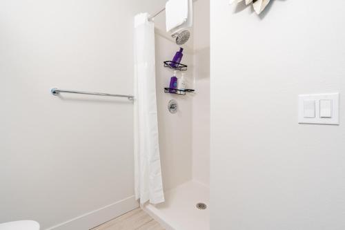a white bathroom with a shower and a toilet at Cityscape Condotel on First Hill-Capitol Hill in Seattle