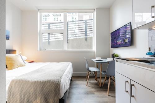 a bedroom with a bed and a desk and a kitchen at Cityscape Condotel on First Hill-Capitol Hill in Seattle
