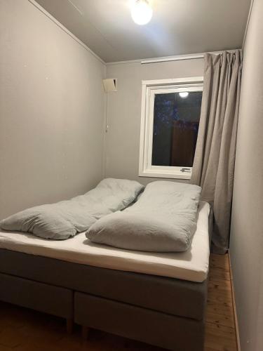 a small bed in a room with a window at Charming apartment in Tromsø