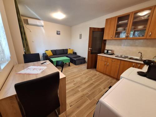 a kitchen and living room with a table and a couch at Бобс апартменти in Kiten