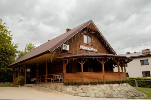 a large wooden building with a roof at Agroturystyka Pawlikówka in Lipniki