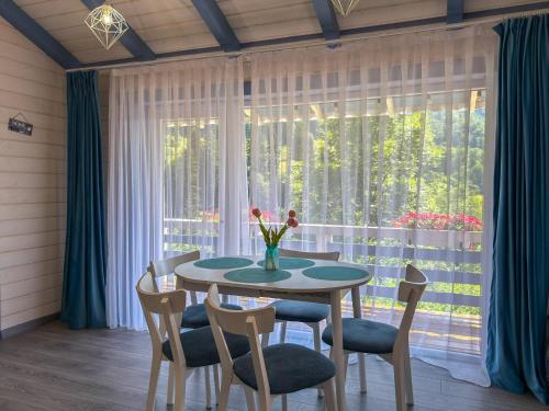 a dining room with a table and chairs and a window at Садиба "Ековид" in Krivorovnya