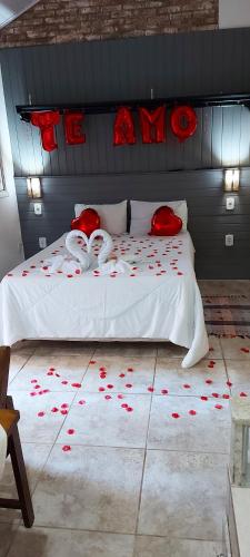 a bedroom with a bed with red roses on it at Suite Canto da Montanha in Monte Verde