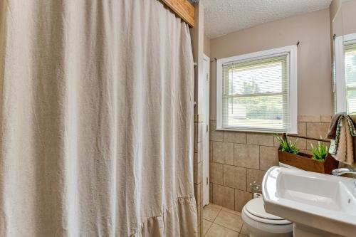 a bathroom with a shower curtain and a toilet and a sink at 8 Mi to Clemson Peaceful Family Home with Yard in Seneca