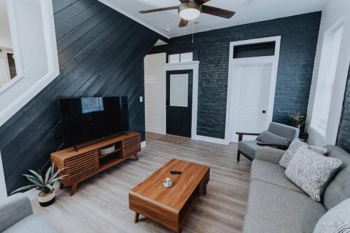 a living room with a couch and a television at Spacious 8BR-4BA Group HQ Patio&Games Soulard in Soulard
