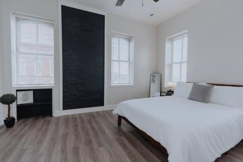 a white bedroom with a large bed and two windows at Spacious 8BR-4BA Group HQ Patio&Games Soulard in Soulard