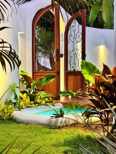 a front door of a house with a garden at Pousada Ilha do Vento in São Miguel do Gostoso