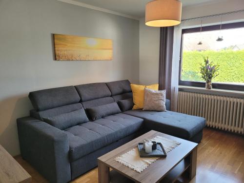 a living room with a blue couch and a table at Fewo "Elsa" Reichmannsdorf - Brötchenservice in Schlüsselfeld