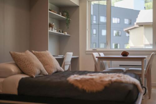 a living room with a couch and a table and a window at Studio At The Crescent Sleeps 2 to 4 in Rossland