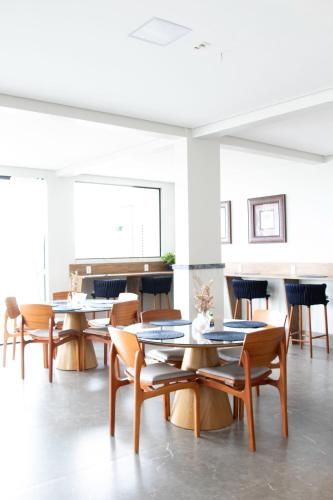 a room with tables and chairs in a building at Antonio's Hotel e Spa - Airport in Brasilia