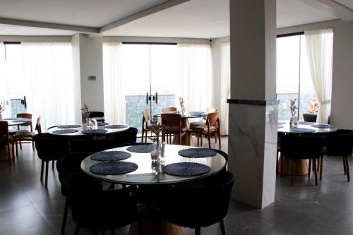 a restaurant with tables and chairs and large windows at Antonio's Hotel e Spa - Airport in Brasilia