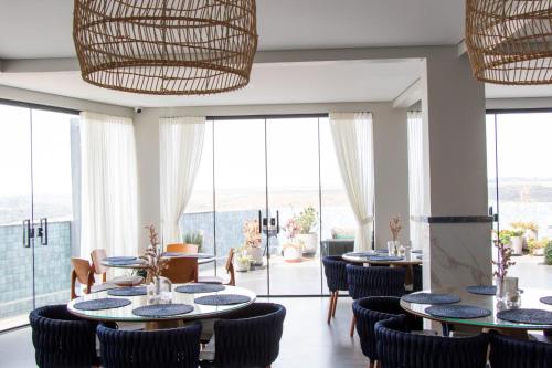 a dining room with tables and chairs and large windows at Antonio's Hotel e Spa - Airport in Brasilia