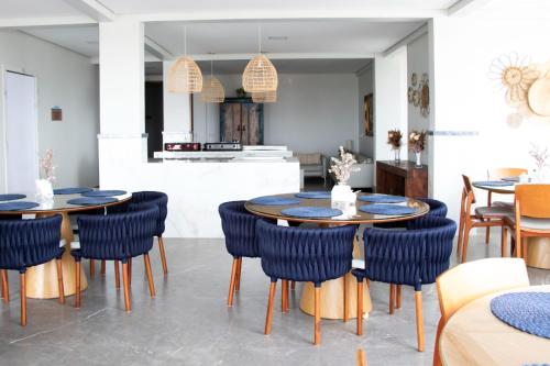 a dining room with two round tables and blue chairs at Antonio's Hotel e Spa - Airport in Brasilia