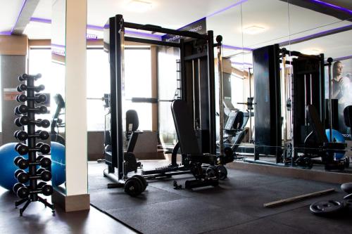 a gym with several tread machines and mirrors at Antonio's Hotel e Spa - Airport in Brasilia