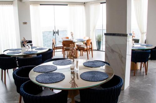 a dining room with tables and chairs and windows at Antonio's Hotel e Spa - Airport in Brasilia