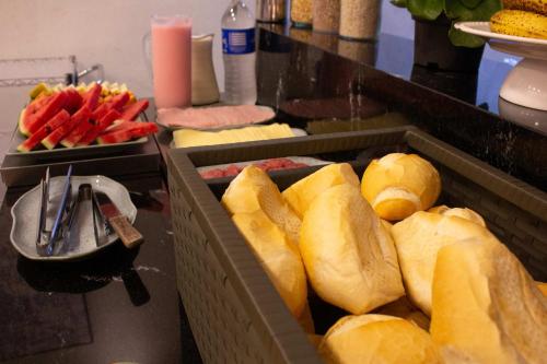 a buffet with buns and other food on a table at Hotel Rosim in Pirassununga