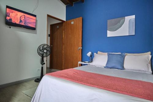 a bedroom with a bed with a blue wall at Apartahotel Poblado-Aguacatala in Envigado
