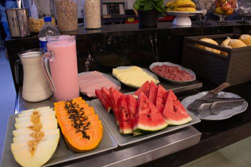 a tray with slices of fruit and cheese on a counter at Hotel Rosim in Pirassununga