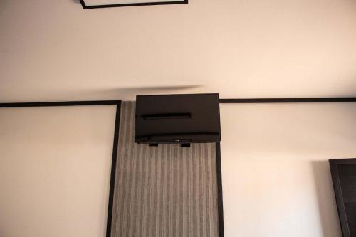 a television on the wall of a room at Hotel Rosim in Pirassununga
