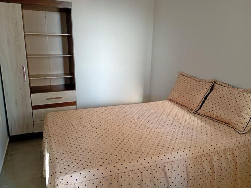 Un dormitorio con una cama con dos almohadas encima. en Apartamento costa Penna, en Santa Rita