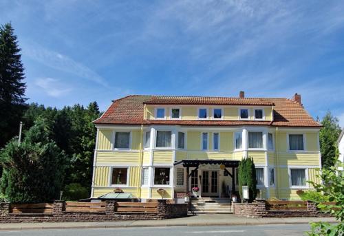 a large yellow house sitting on the side of a street at Pension Haus Sonneck in Wildemann