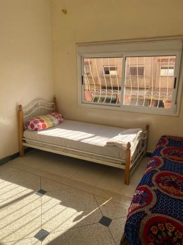 a bed sitting in a room with a window at Azrou in Azrou