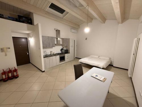 a living room with a table and a kitchen at Le Torri Lodge, exclusive comfort in the center in Forlì