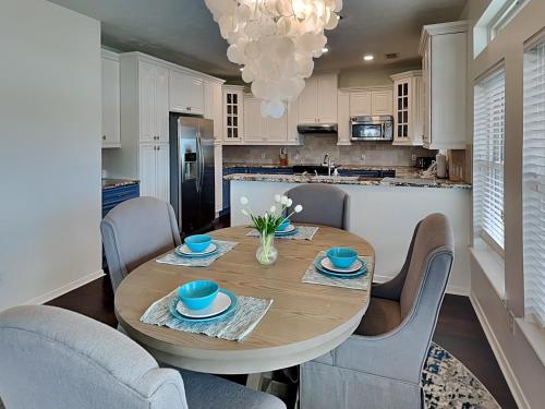 a kitchen with a wooden table with chairs and a dining room at West Bay Getaway in Galveston