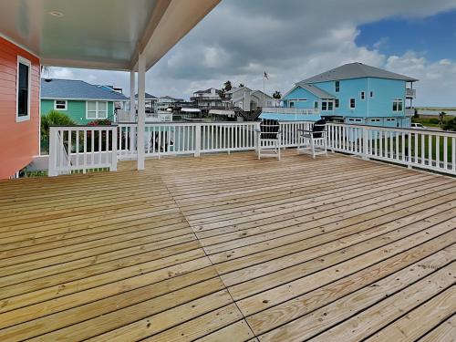 a wooden deck with chairs on a house at West Bay Getaway in Galveston