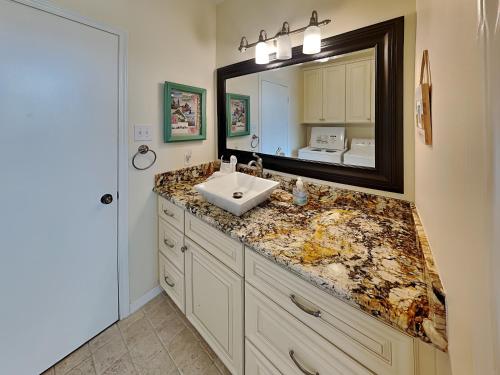a bathroom with a sink and a large mirror at West Bay Getaway in Galveston