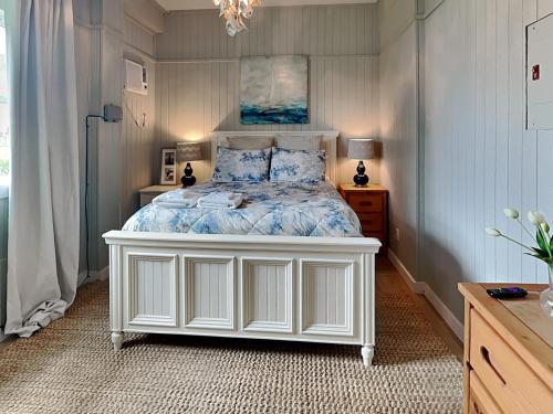 a bedroom with a white bed with blue pillows at West Bay Getaway in Galveston