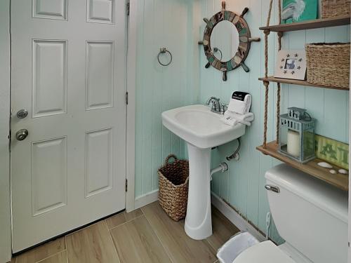 a bathroom with a sink and a mirror and a toilet at West Bay Getaway in Galveston