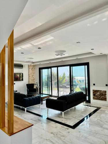 una sala de estar con 2 sofás negros y una ventana grande en Villa Rodino, 