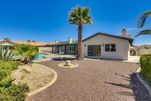 a palm tree in front of a house at Pool, Spa and Mountain Views Apple Valley Retreat! in Apple Valley