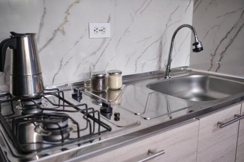 a kitchen with a stove and a sink at Apartahotel Poblado-Aguacatala in Envigado