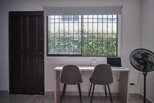 a room with a desk with two chairs and a window at Apartahotel Poblado-Aguacatala in Envigado
