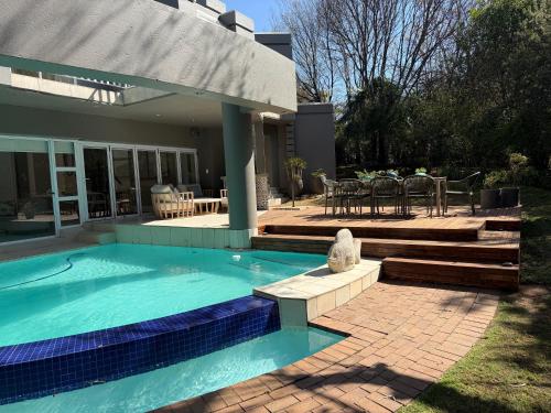 a swimming pool in front of a house at Wellness Guesthouse in Krugersdorp