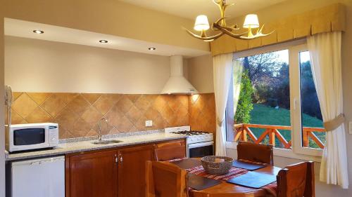 a kitchen with a table and a microwave at El Nautico Lodge Bariloche in San Carlos de Bariloche