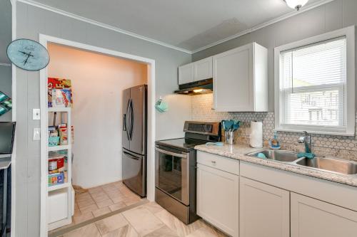 a kitchen with white cabinets and a stainless steel refrigerator at Private Bayfront Access 10 Mi to Galveston Beaches in Hitchcock
