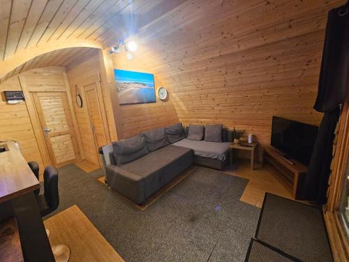 a living room with a couch and a tv at Glamping Pod with Wood Fired Hot Tub in Scarborough