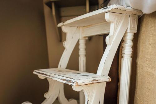 a wooden stair case with a white chair next to it at Elowen Suites Downtown in Drumheller