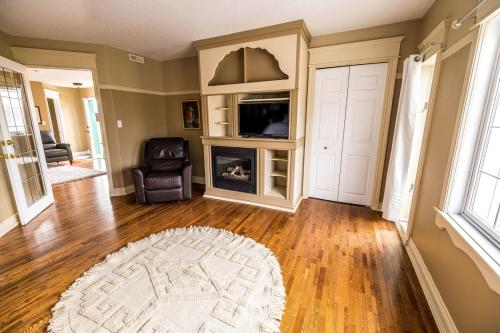a living room with a fireplace and a television at Elowen Suites Downtown in Drumheller