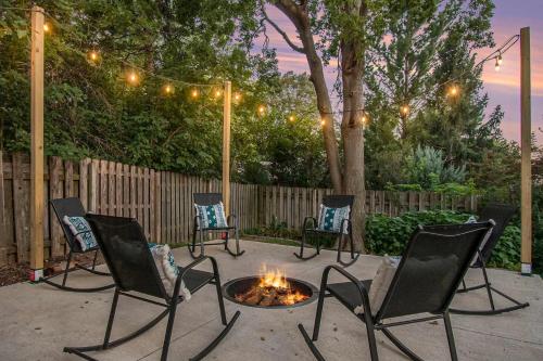 a group of chairs sitting around a fire pit at Central Family Oasis with Hot Tub & Fenced Yard in Omaha