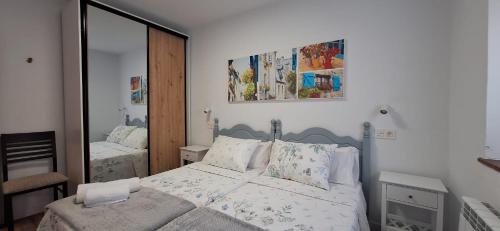 ein Schlafzimmer mit einem Bett und einem großen Spiegel in der Unterkunft El Rincón de Silvia in Villaviciosa