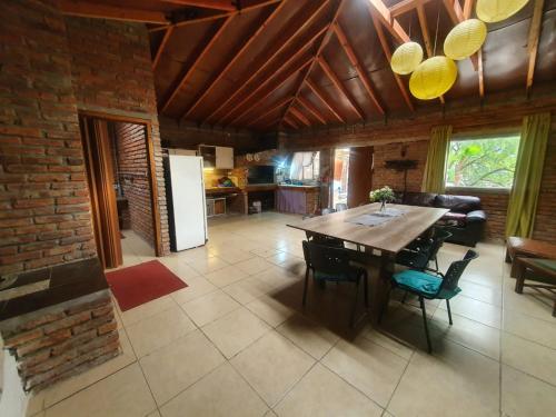 a kitchen and dining room with a wooden table and chairs at Cabaña Jaureguiberry sur para 10 in Jaureguiberry