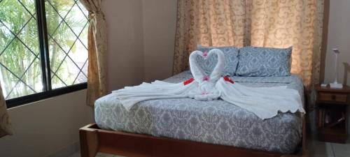 a bed with two swans made out of towels at Casa Plumeria-Aloha Surf Nosara in Nosara